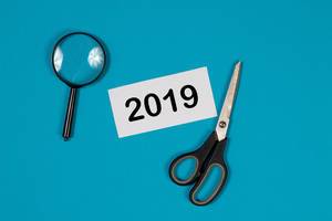 2019 text and scissors on blue background