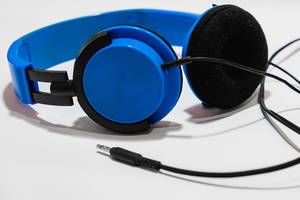 A blue headphones on white surface