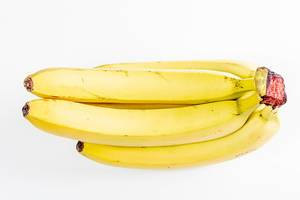 A branch of ripe bananas on a white background