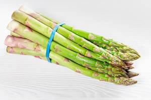 A bunch of fresh asparagus on a white wooden table (Flip 2019)