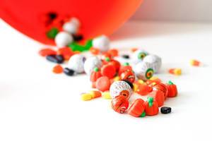 A bunch of orange and white Halloween candies on a white table