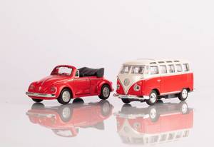 A classic red minibus and red beetle car