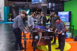 A few persons playing virtual table football Koliseum VR Series with VR glasses