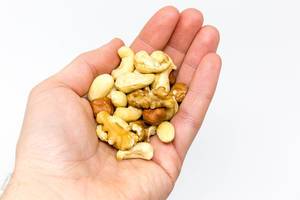 A handful of different nuts such as walnuts, cashew nuts, almonds and hazelnuts