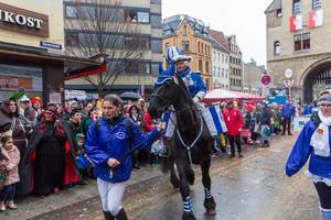 A horse rider of the Blaue Funken, traditional carnival society of Cologne, is accompanied during the Rose Monday Parade at Severinstorburg