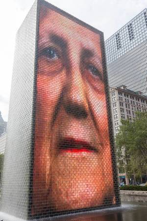A human face is displayed on one of the two glass brick towers at the interactive Crown Fountain designed by Catalan artist Jaume Plensa