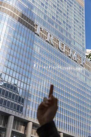 A man shows the middle finger as a political statement against US President Trump in front of the Trump Tower in Chicago