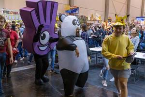 A mascot of the Dobble card game, a man in a panda costume and a girl in a Pokemon mask at the international gaming fair SPIEL 19 in Essen, Germany