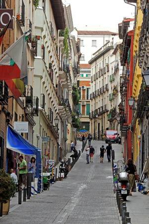 A narrow, winding street in the city of Madrid, Spain