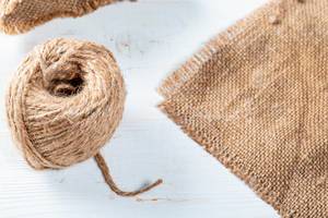 A piece of burlap fabric and a ball of thread