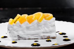 A piece of cake with Meyer lemon curd, white cream, and chocolate sauce
