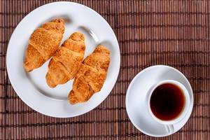 A plate with croissants and a Cup of tea, Breakfast concept