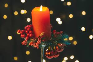 A red candle burns on a dark background with bokeh (Flip 2019)