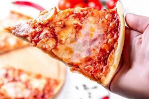 A slice of pizza in hand close-up
