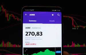 A smartphone displays the Adobe Inc. market value