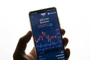 A smartphone displays the Tron market value on the stock exchange
