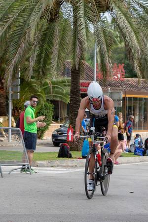 A sportsman rides barefoot on the bicylce at a triathlon