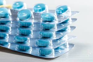 A stack of blue pills in the package close-up (Flip 2019)