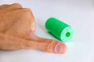 A thumb next to the green fascia roll Blackroll, for regeneration exercises and massages