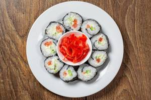 A top view of a plate of Maki rolls and pickled pink ginger