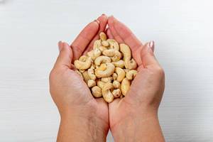 A woman holds dry not fried cashew nuts (Flip 2019)