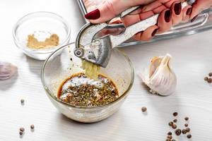 Adding garlic to spicy marinade close up