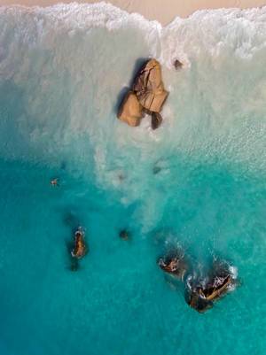 Aerial photography of crystal clear water at shore of Anse Lazio with its granite stone formations on the tropical Island Praslin, Seychelles