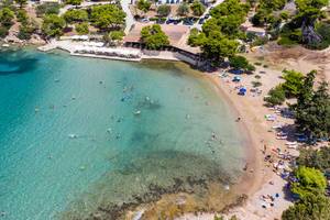 Aerial picture of people swimming in the blue sea and enjoying their vacation on Hinitsa Beach in Ermionida