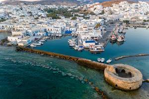Aerial view of a harbour basin at the picturesque island town Naoussa on Paros (Greece) & ruins of an old Venetian castle in the Mediterranean Sea