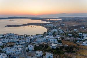 Aerial view of a sunset at the horizon of Aegean Sea and small island town Naoussa on Paros, Greece