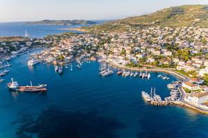 Aerial view of boats and a cargo ship in a port between Agios Mamas and Agios Nikolaos, on the Greek island Spetses in the Argolic Gulf