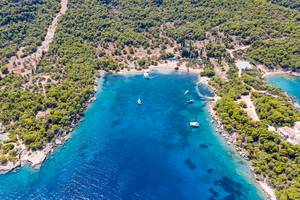 Aerial view of luxury yachts in the blue sea at Ekklisia Analipsi beach at Spetses, Greece