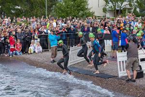 After a rolling swim start triathletes run into lake Vesijärvi for their Ironman swimming competition