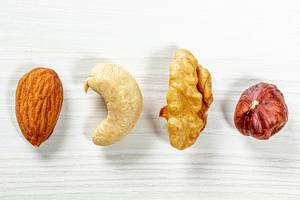 Almonds, cashews, hazelnuts, walnuts on white wooden background. Top view