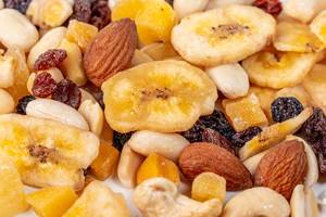 Almonds, peanuts, cashews and dry bananas, raisins with candied fruits-background