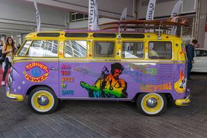Alter, bunter VW-Bus im Flower Power Hippie Look: Jimi Hendrix und All you need is love, mit Surfbrettern auf dem Dachgepäckträger