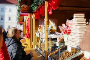 Ältere Frau kauft Süßigkeiten auf dem Weihnachtsmarkt