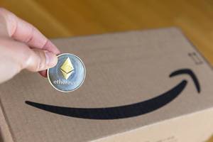 Amazon Cloudsystem Blockchain Templates für Ethereum  - Hand hält silber-und goldfarbene Ethereum Münze mit Diamant-Logo in der Mitte