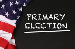 American flag with the text Primary Election against a blackboard background.jpg