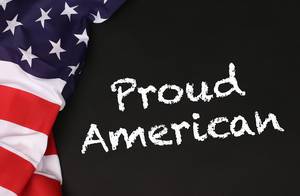 American flag with the text Proud American against a blackboard background.jpg
