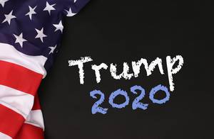 American flag with the text Trump 2020 against a blackboard background