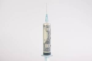 Amerikanischer 100$ Geldschein in einer Spritze mit Injektionsnadel