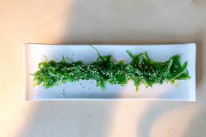 Ansicht von oben auf proteinhaltige und vitaminreiche vegane Algen im Goma Wakame Salat, mit gesunden Sesamkernen