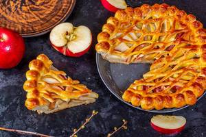Apple pie-Charlotte with fresh apples on a black background