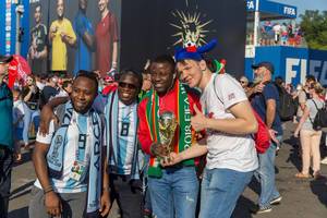 Argentinian soccer fans with trophy posing for photos