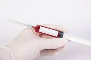 Arzt hält eine Blut-Spritze mit freiem Platz für Text