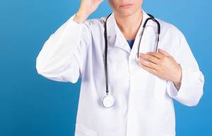 Ärztin mit einem Stethoskop in blauem Hintergrund