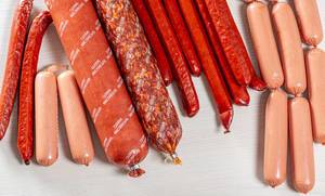 Assortment of sausages on white wooden background