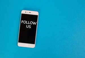 Aufschrift "Follow Us"  - Abonniere uns - auf dem schwarzen Display eines Handys