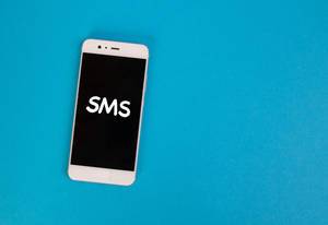 Aufschrift "SMS" auf dem schwarzen Display eines Smartphones